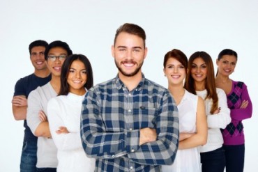 Portrait of happy young casual people with arms folded over white background